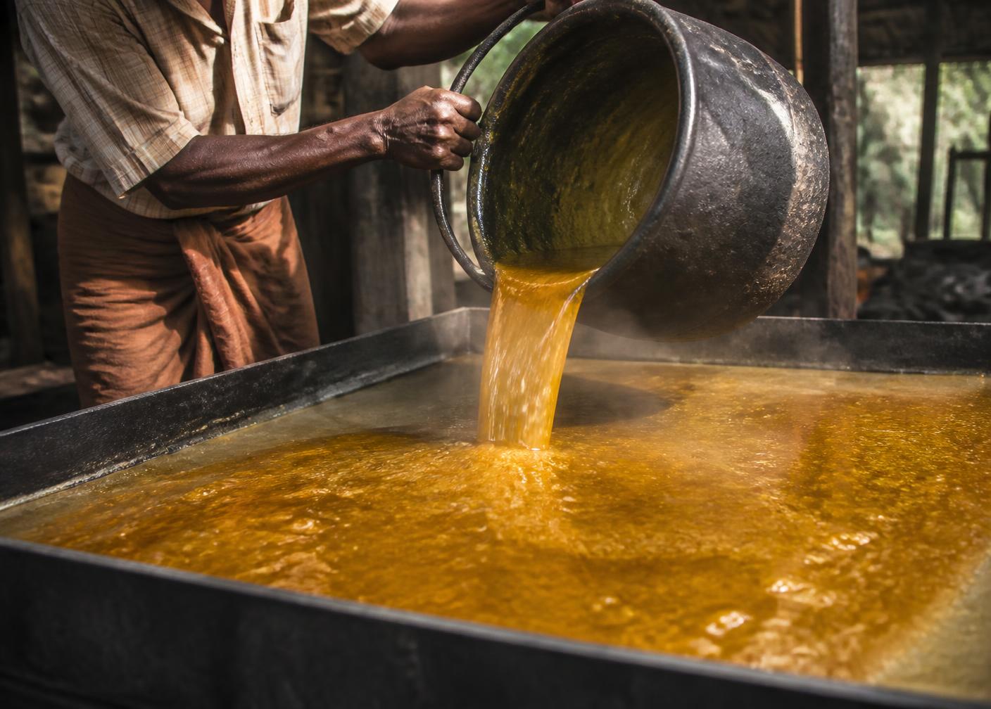 Molten pure jaggery being poured into a traditional Kerala setting tray